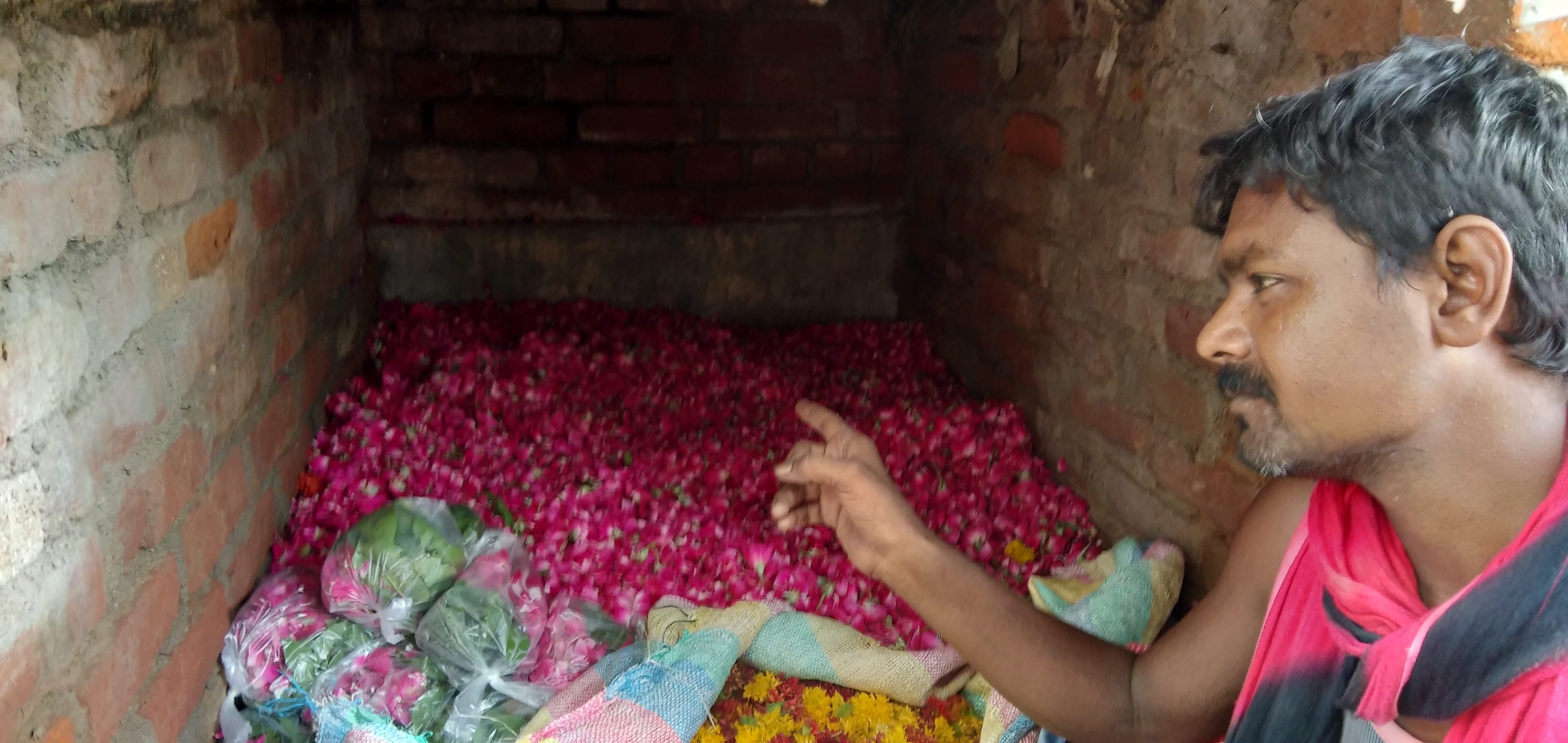गोदाम में फूलों का ढेर दिखाता कारोबारी। गोदाम में फूलों का ढेर दिखाता कारोबारी।