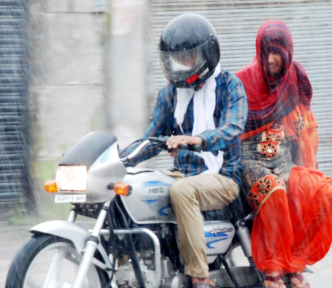 शामली बरसात में महिला को बाइक पर लेकर जाता युवक शामली बरसात में महिला को बाइक पर लेकर जाता युवक
