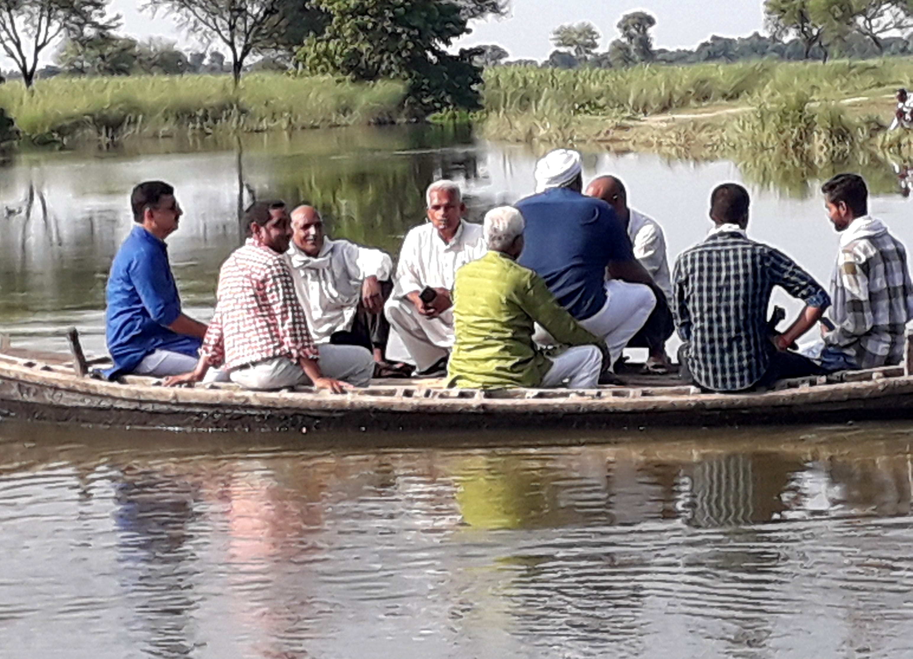 सगड़ी के खरैलिया घाट पर पुलिया के बह जाने से नाव के सहारे सफर करते लोग।