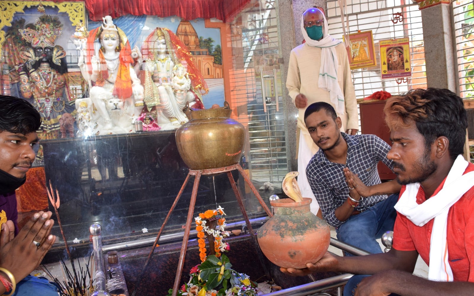 शहर के पुरानी कोतवाली स्थित शिव मंदिर में नाग पांचमी के अवसर पर नाग देवता का दर्शन करते श्रद्धालु
