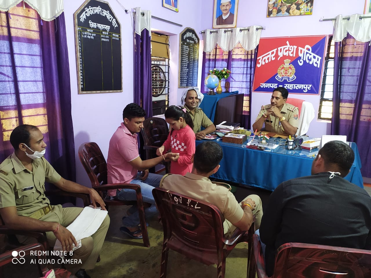 अंबेहटा पुलिस चौकी में पुलिसकर्मियों को राखी बांधती बच्ची अंबेहटा पुलिस चौकी में पुलिसकर्मियों को राखी बांधती बच्ची