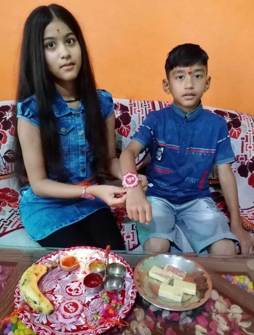 रुद्रपुर में ऐंपण की राखी भाई की कलाई में बांधती बहन।