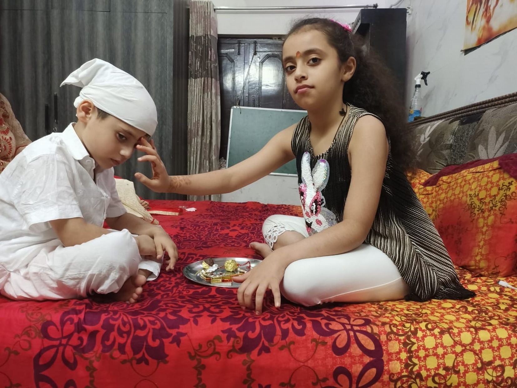काशीपुर में भाई की कलाई पर राखी बांधती बहन।