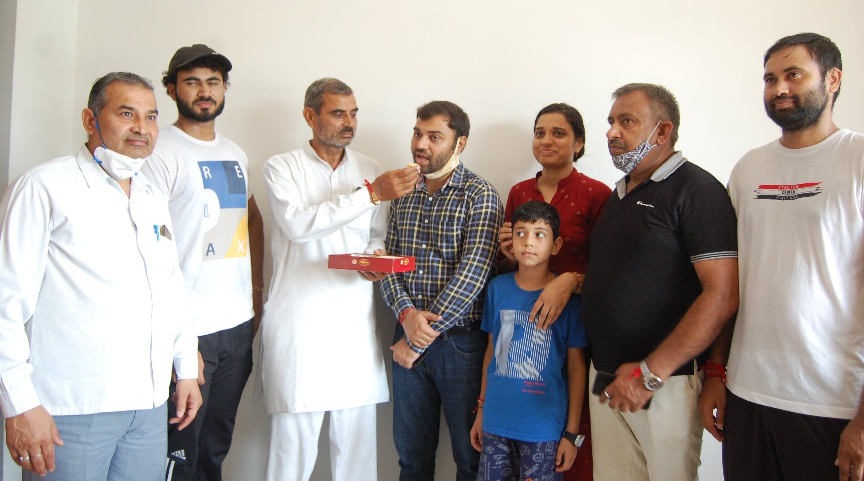 यूपीएससी में टॉपर बनने पर बेटे प्रदीप सिंह मलिक को मिठाई खिलाते सुखबीर मलिक, साथ में परिजन।