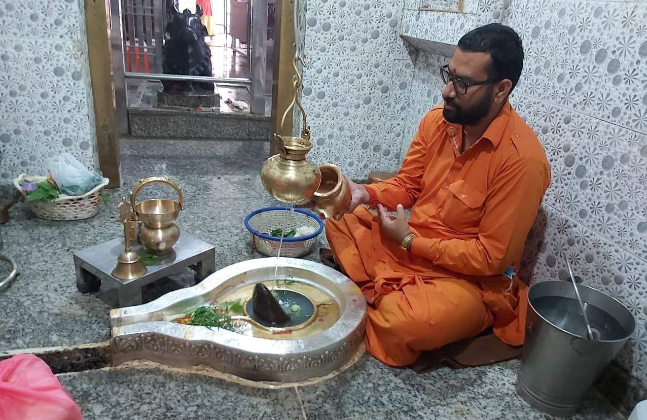 नीलकंठ महादेव मंदिर में पूजा अर्चना करते पुजारी। नीलकंठ महादेव मंदिर में पूजा अर्चना करते पुजारी।