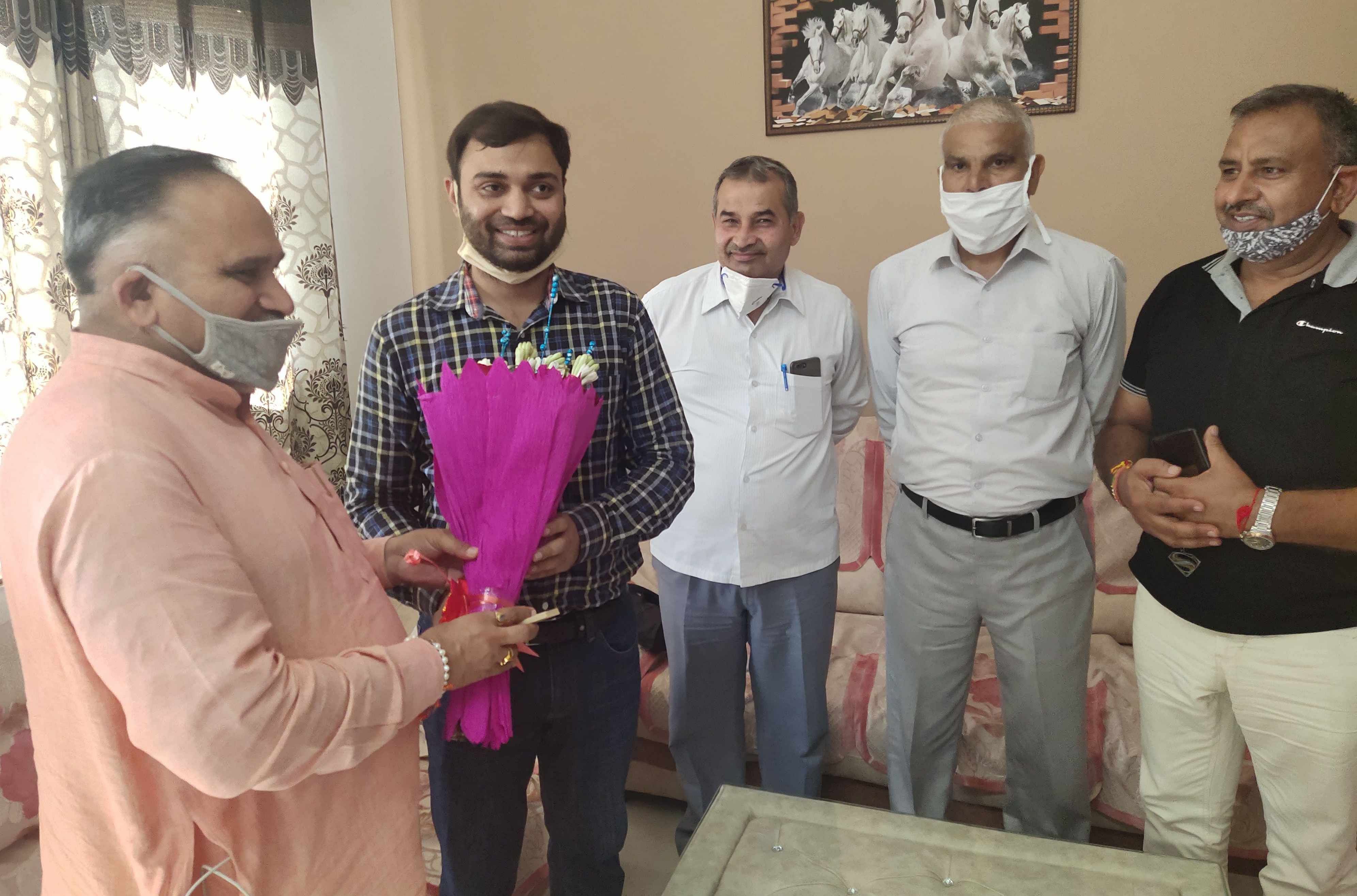 यूपीएससी के टॉपर प्रदीप सिंह को गुलदस्ता भेंट करते सीएम के पूर्व मीडिया सलाहकार राजीव जैन