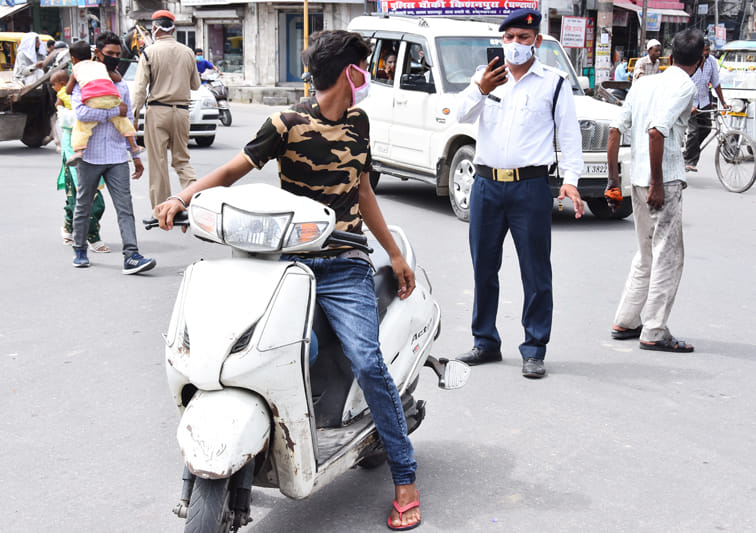 सहारनपुर के घंटाघर स्कूटी सवार का ईचालान करता यातायात कर्मी सहारनपुर के घंटाघर स्कूटी सवार का ईचालान करता यातायात कर्मी