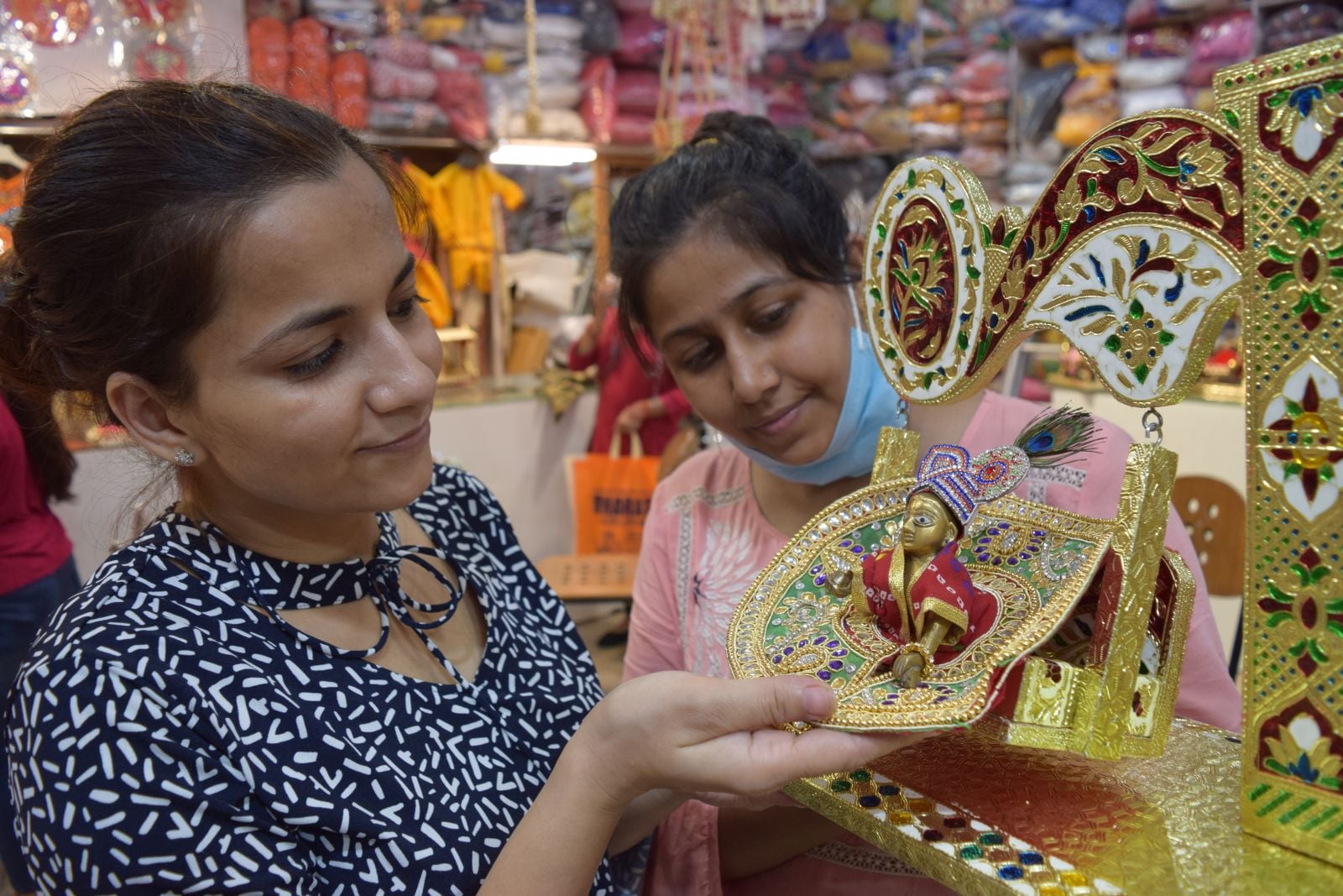बाजार में कृष्ण जन्माष्टमी पर खरीदारी करते लोग। बाजार में कृष्ण जन्माष्टमी पर खरीदारी करते लोग।