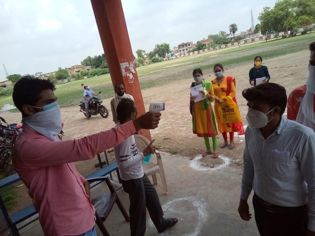 जीआईसी स्कूल में छात्रों की थर्मल स्क्रीनिंग करता कर्मचारी जीआईसी स्कूल में छात्रों की थर्मल स्क्रीनिंग करता कर्मचारी