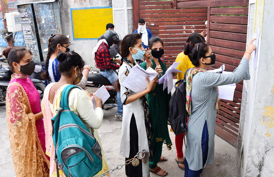 सहारनपुर के एसएएम इंटर कॉलेज में बीएड की परीक्षा देने जाने से पहले सीट नंबर देखती छात्राएं