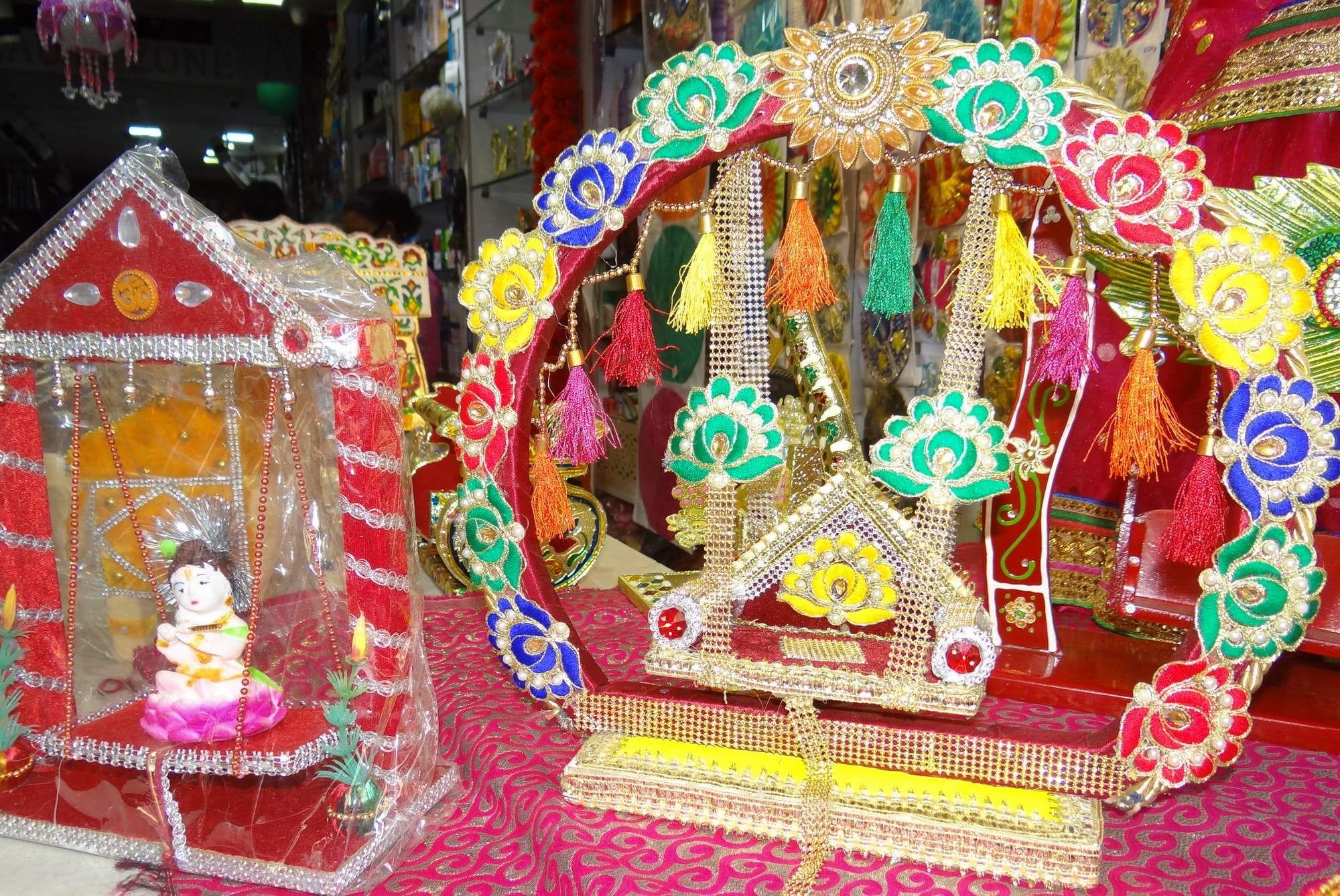 दुकानों में रखे कान्हा के सजे झूले। दुकानों में रखे कान्हा के सजे झूले।