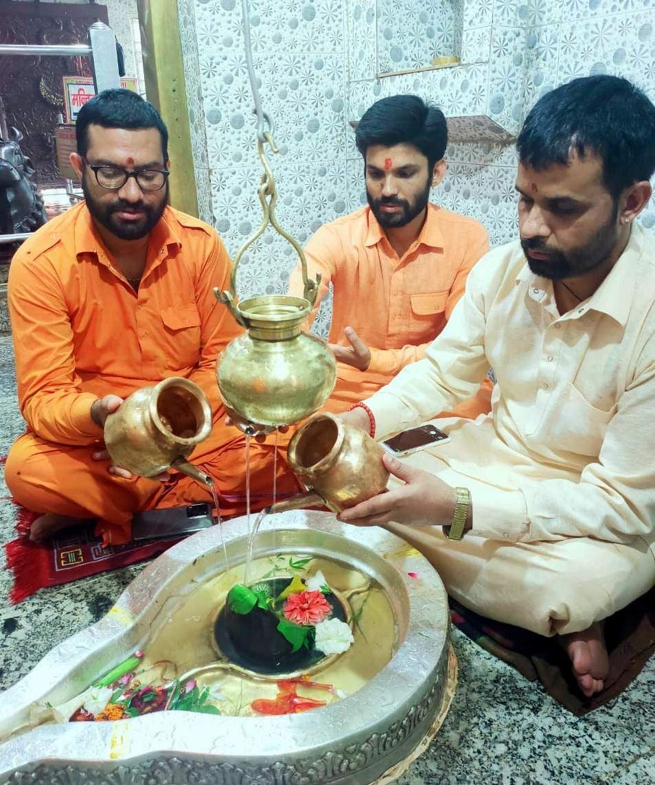 नीलकंठ मंदिर में दुग्धाभिषेक करते पुजारी। नीलकंठ मंदिर में दुग्धाभिषेक करते पुजारी।