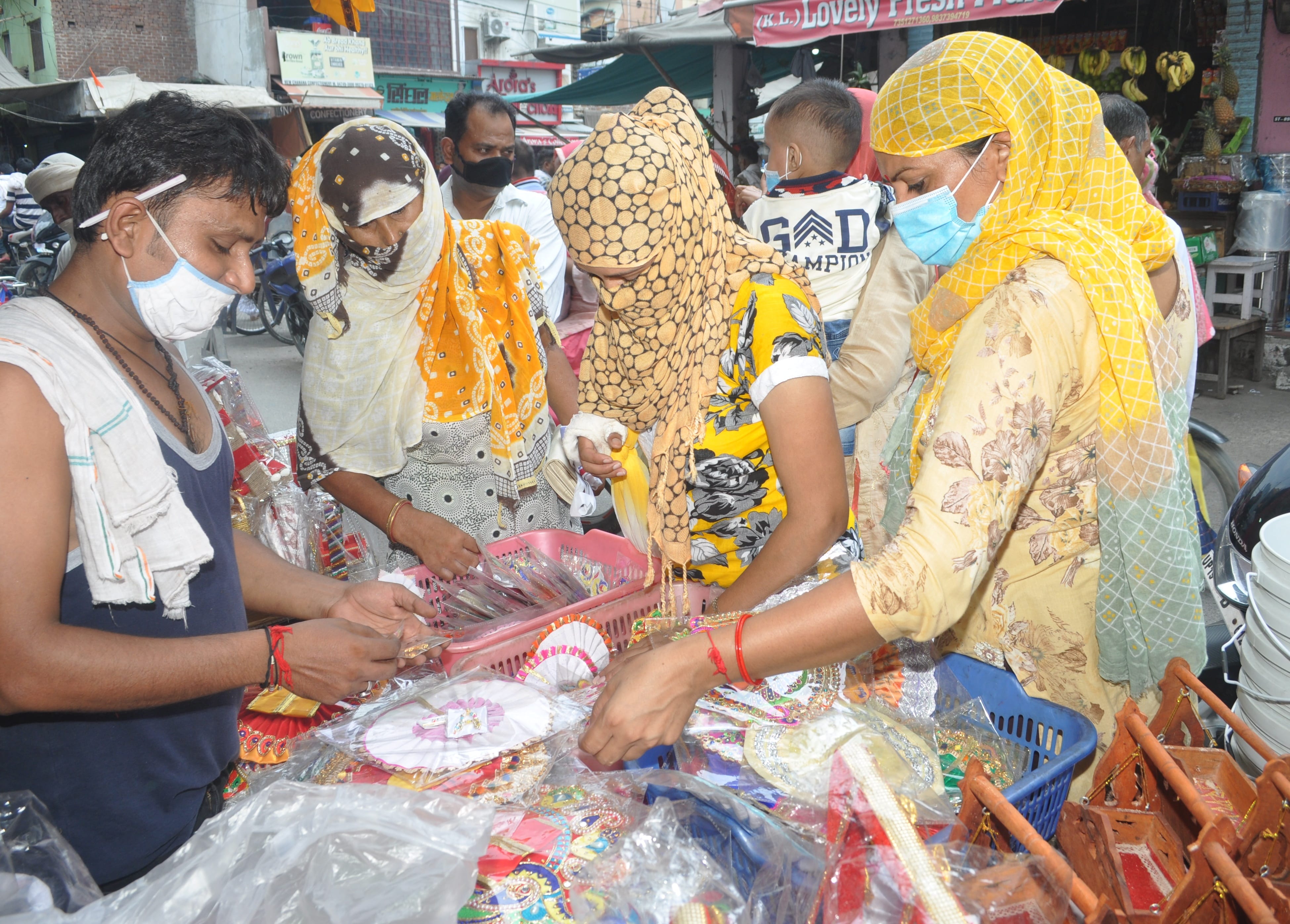श्रीकृष्ण जन्माष्टमी पर दुकानों पर खरीदारी करतीं महिलाएं।