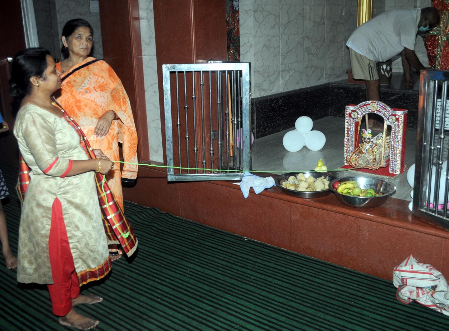ामली मंदिर में लडडू गोपाल के पालने को झुलाती महिला