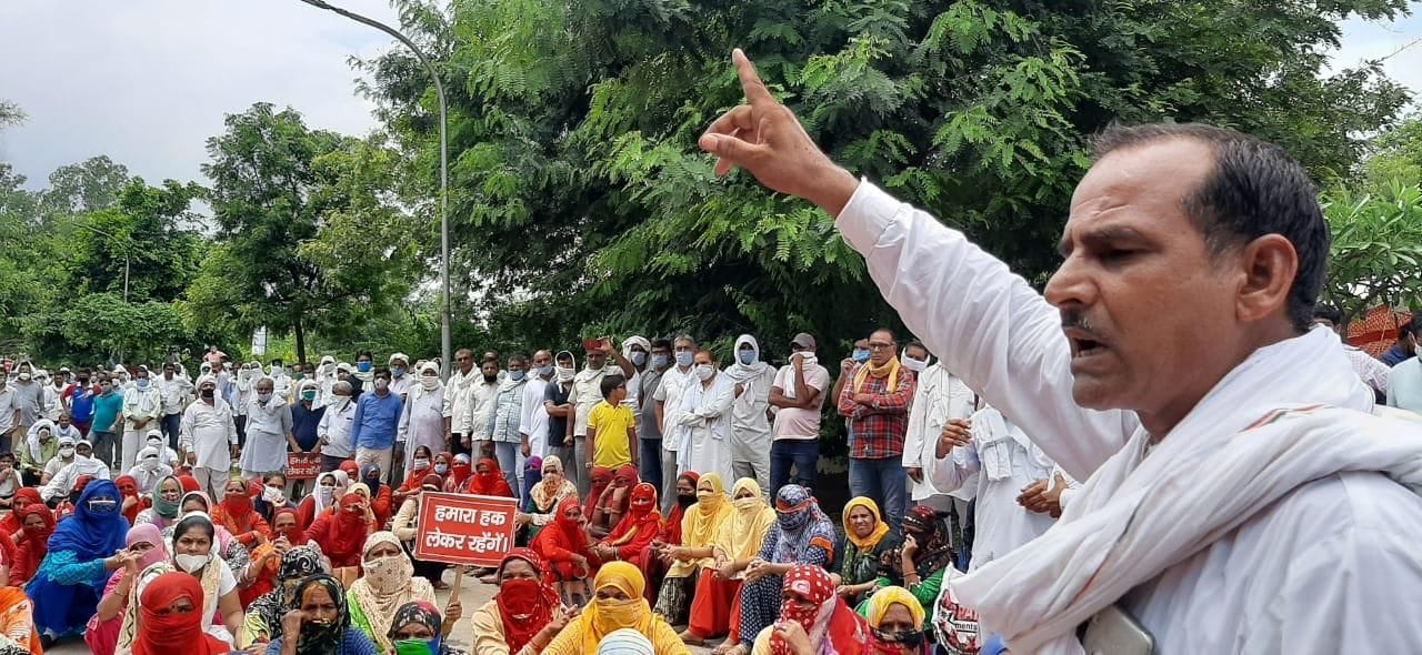 प्रदर्शनकारियों को संबोधित करते कर्मचारी नेता।