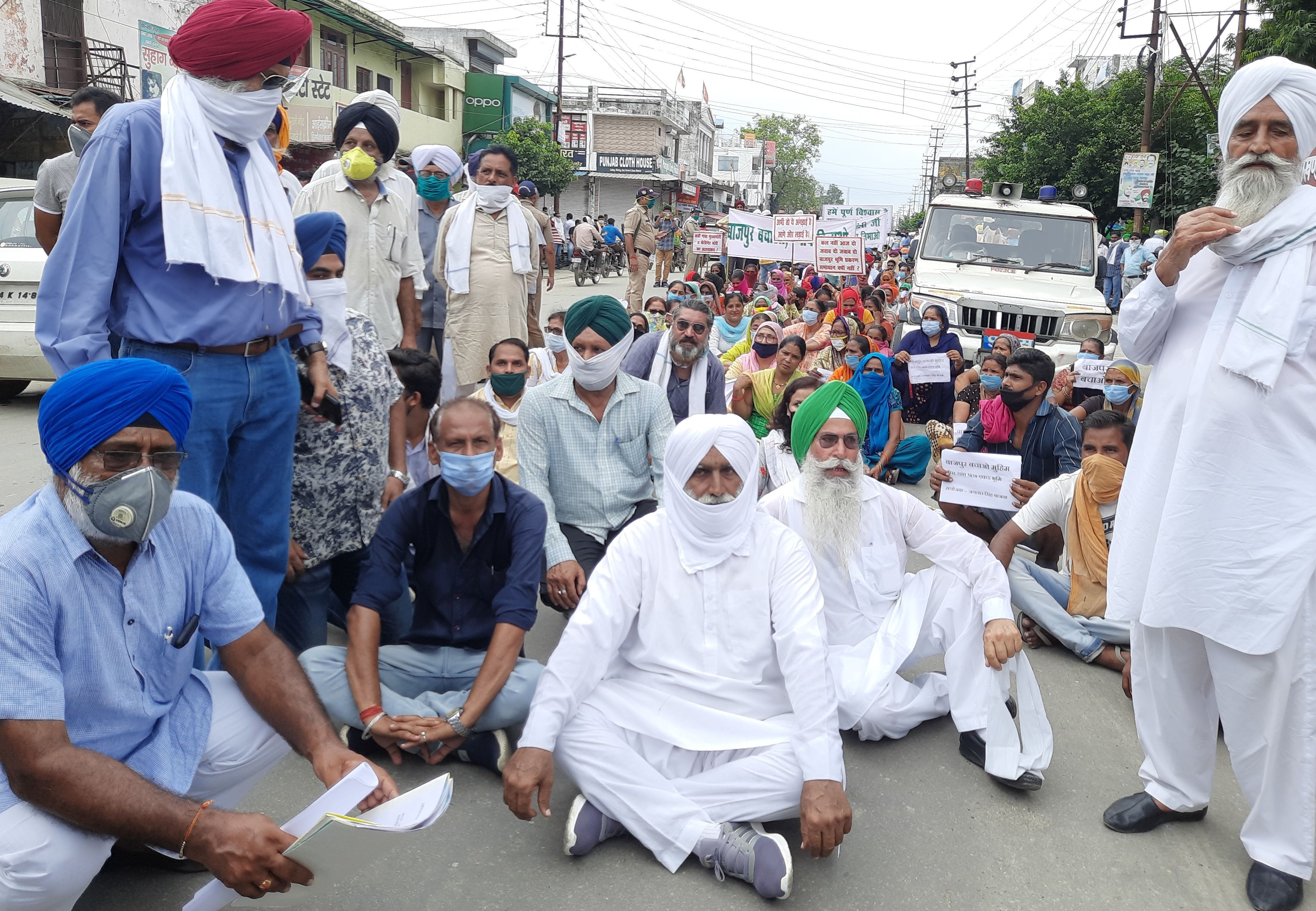 बाजपुर तहसील के सामने सड़क पर बैठे लोग। बाजपुर तहसील के सामने सड़क पर बैठे लोग।