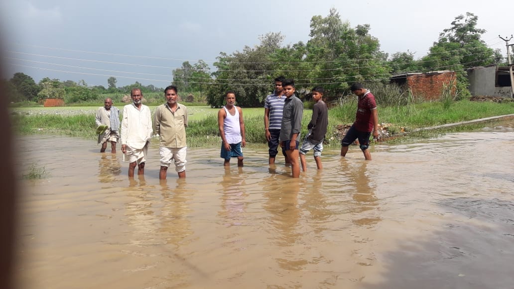 तालाब के पानी के सड़क पर आने से जलभराव के कारण परेशान ग्रामीण