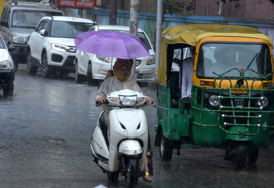 सहारनपुर में हुई बरसात में दिल्ली रोड़ की और स्कूटी पर छाता लेकर जाती महिलाएं सहारनपुर में हुई बरसात में दिल्ली रोड़ की और स्कूटी पर छाता लेकर जाती महिलाएं