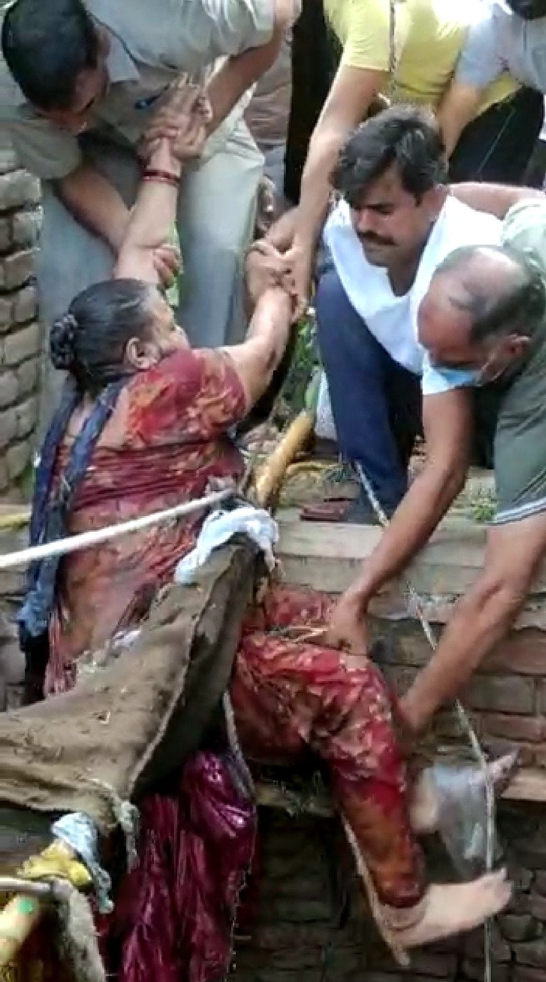 कुएं मे गिरी महिला को बाहर निकालते लोग। कुएं मे गिरी महिला को बाहर निकालते लोग।