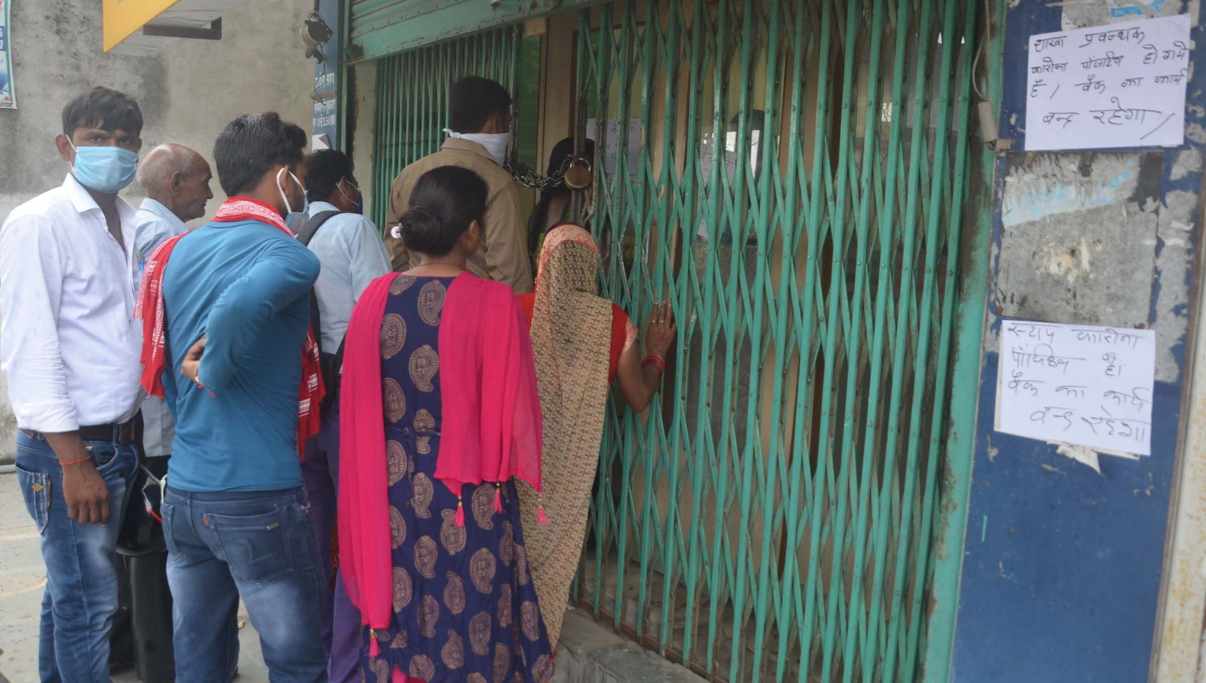 मीरा भवन स्थित बैंक में प्रबंधक के कोरोना पाजटिव आने के बाद बंद गेट पर भीड़ लगाये ग्राहक।