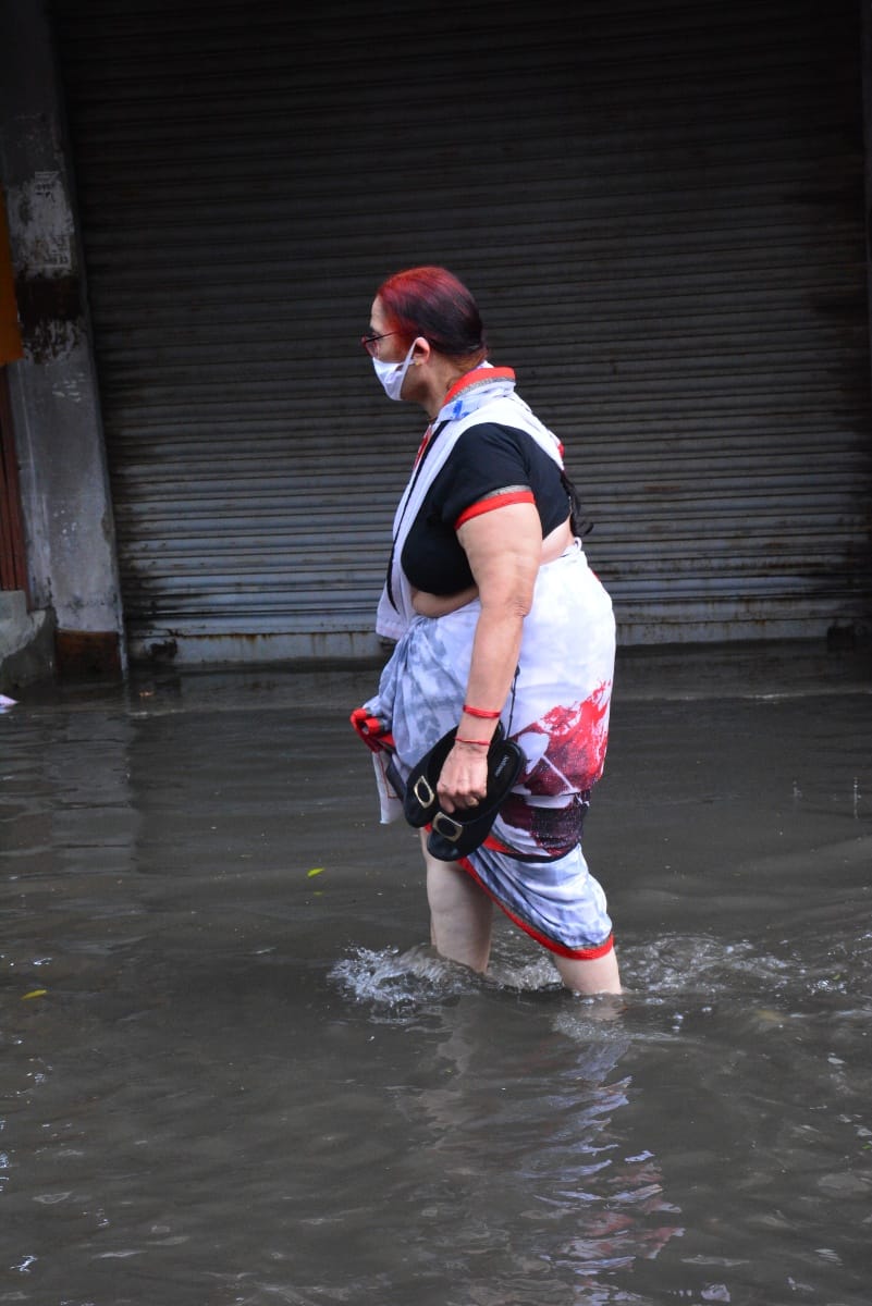 एसडी कालेज मार्किट पर बारिश से हुए जलभराव से गुजरती महिला। एसडी कालेज मार्किट पर बारिश से हुए जलभराव से गुजरती महिला।