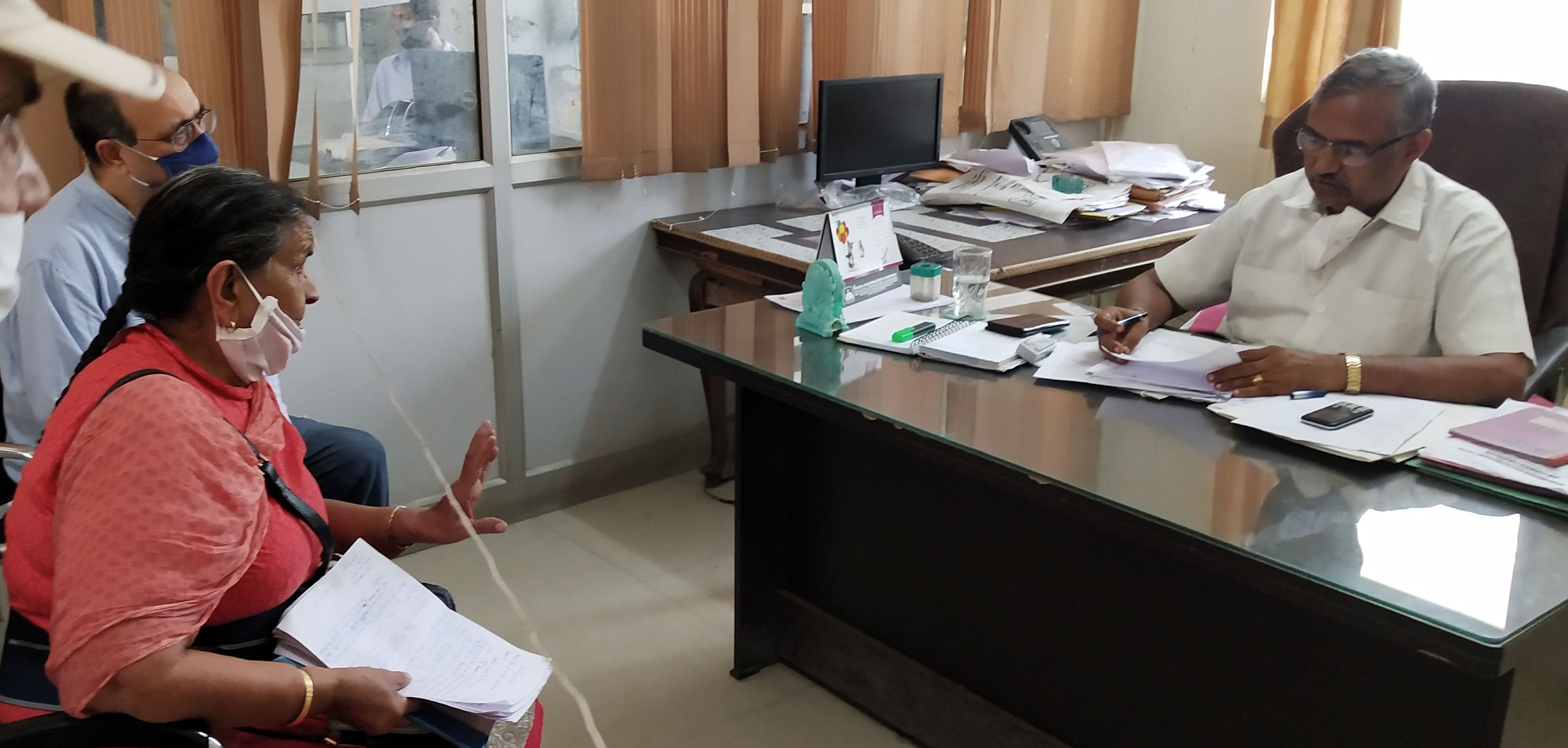 सोशल डिस्टेंसिंग के तहत उपभोक्ताओं से बातचीत करते अधिकारी। 