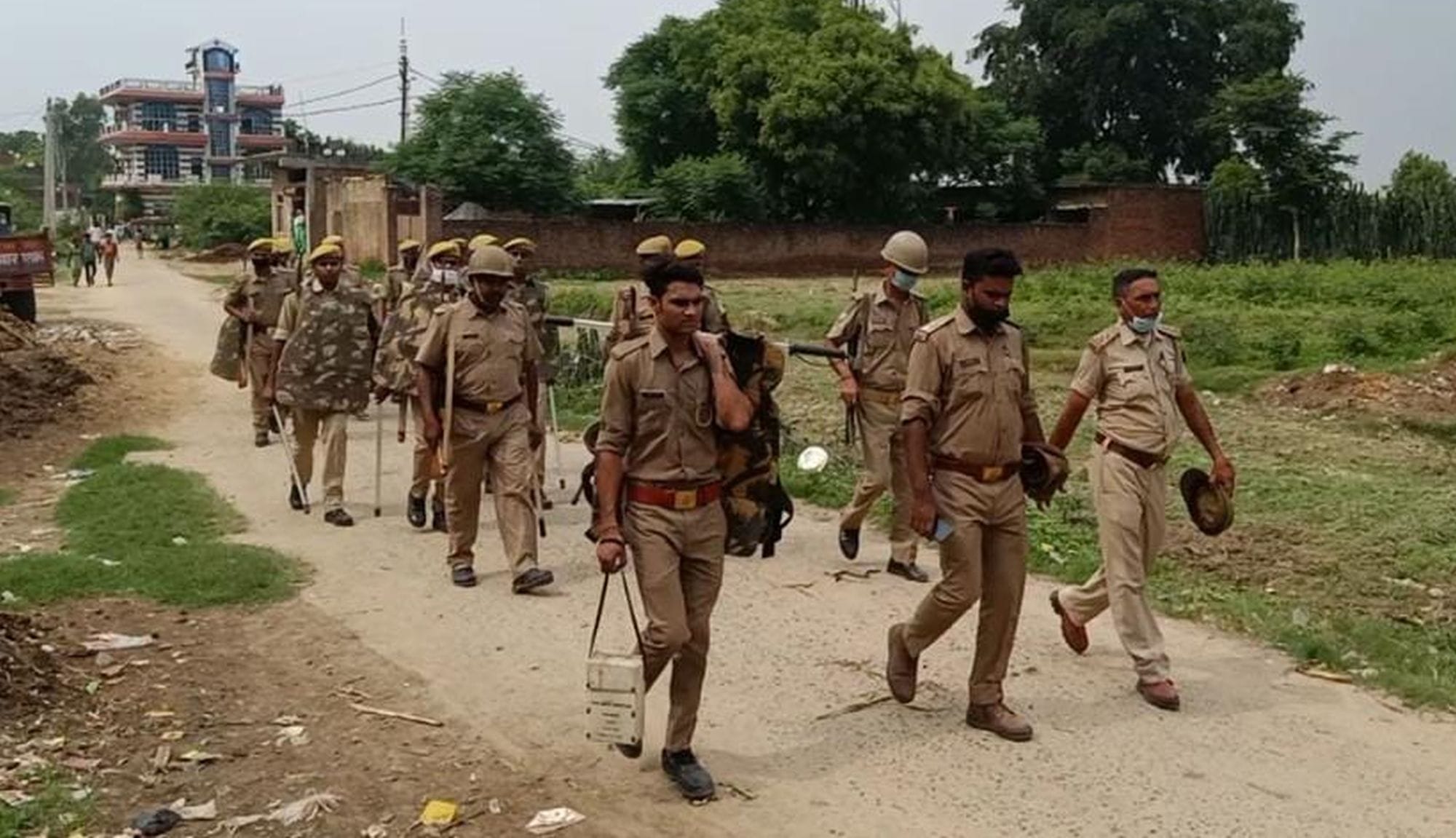 बिल्हौर (कानपुर) के मकनपुर-इलियासपुर गांव में पैदल मार्च करते पुलिस-पीएसी के जबान 