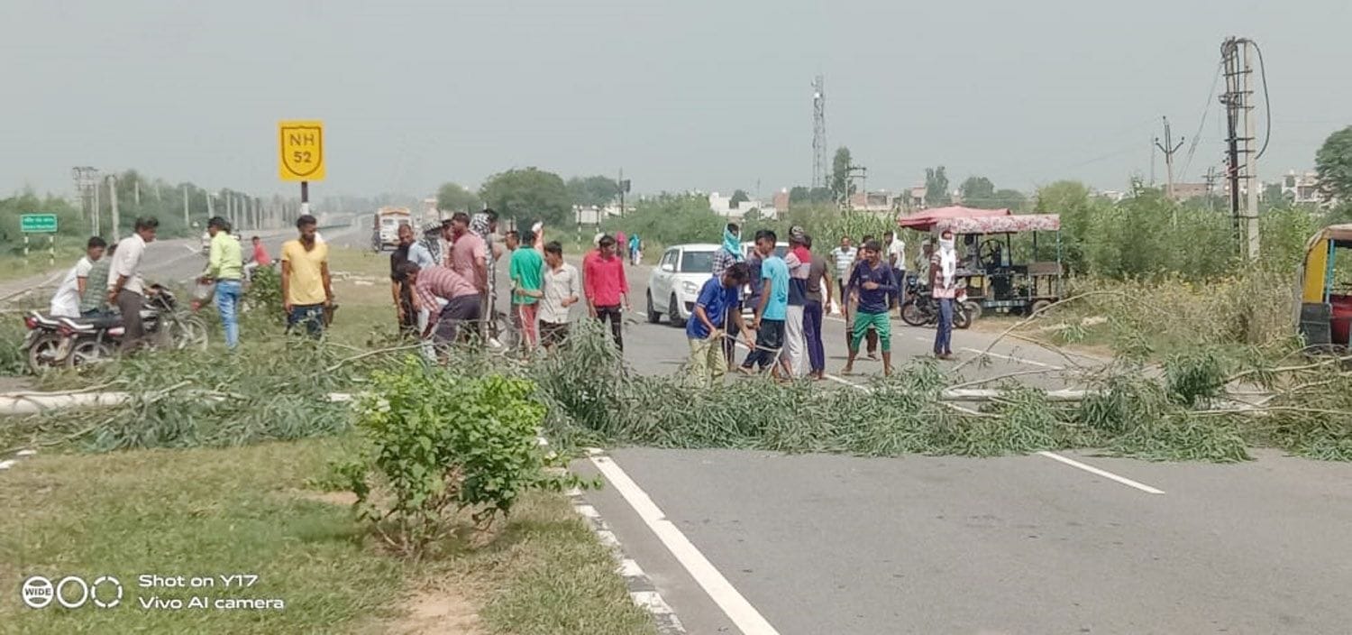  दिल्ली-पटियाला हाईवे पर पेड़ों को काटकर जाम लगाते किसान।