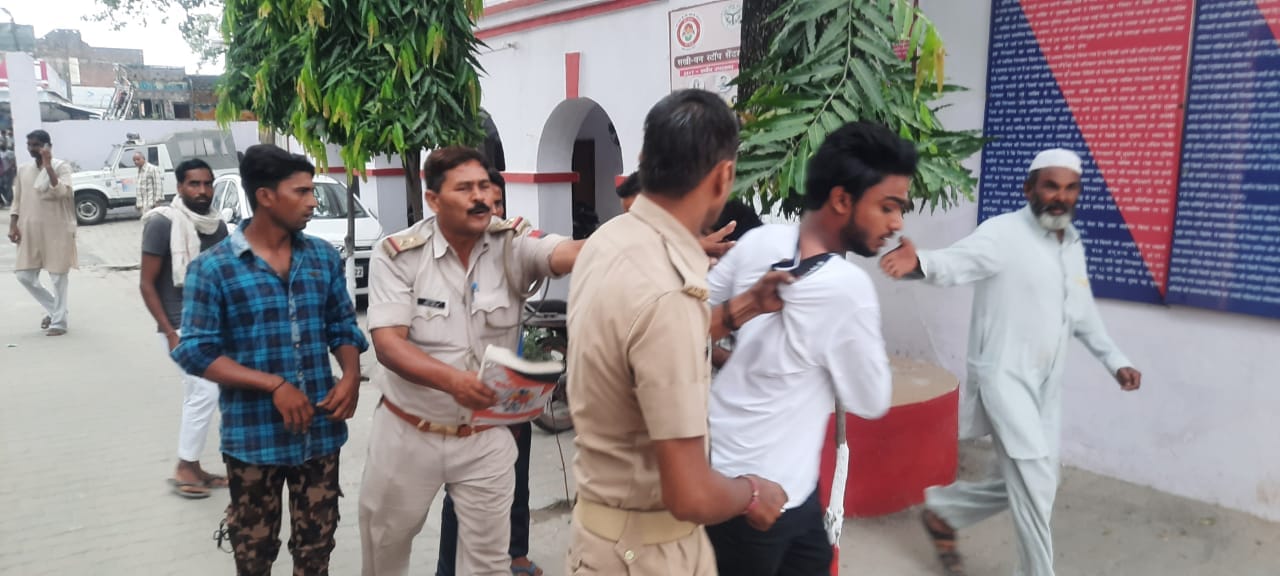 कोतवाली में हंगामा करती भीड़ में शामिल युवकों को हिरासत में लेकर जाती पुलिस