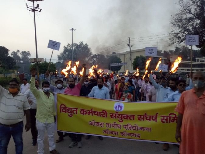 ओबरा में मशाल जुलूस निकाल कर विरोध करते बिजली कामगार।