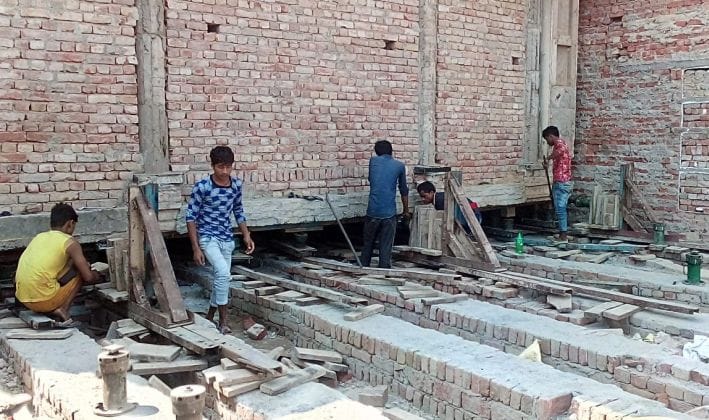 एटाः हाईवे से जैक लगाकर मंदिर को पीछे करते कर्मचारी- संवाद एटाः हाईवे से जैक लगाकर मंदिर को पीछे करते कर्मचारी- संवाद