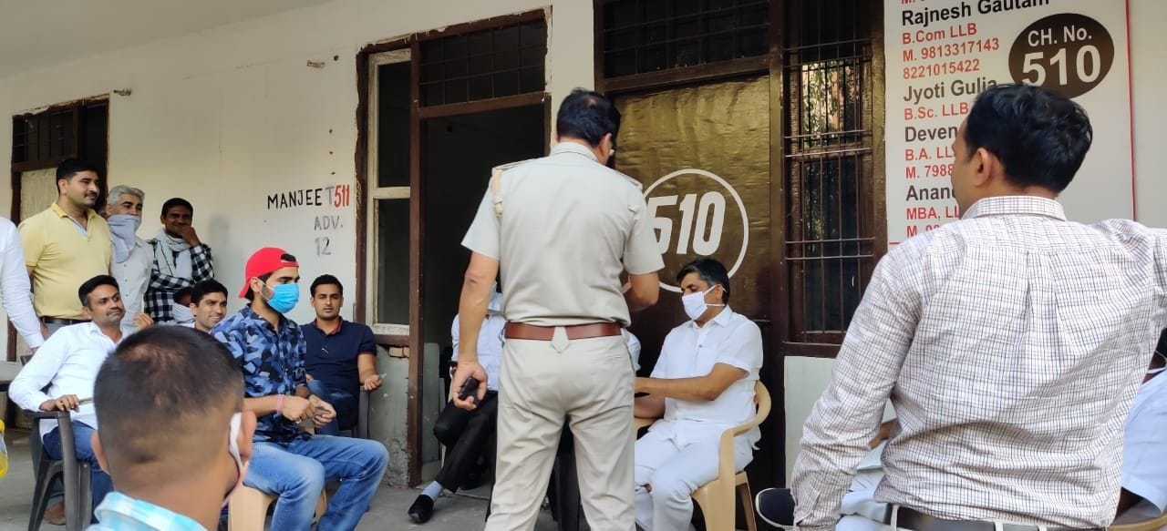 विवाद को निपटाने के लिए वकीलों से बात करते आर्यनगर थाने के सहायक थाना प्रभारी जयभगवान।