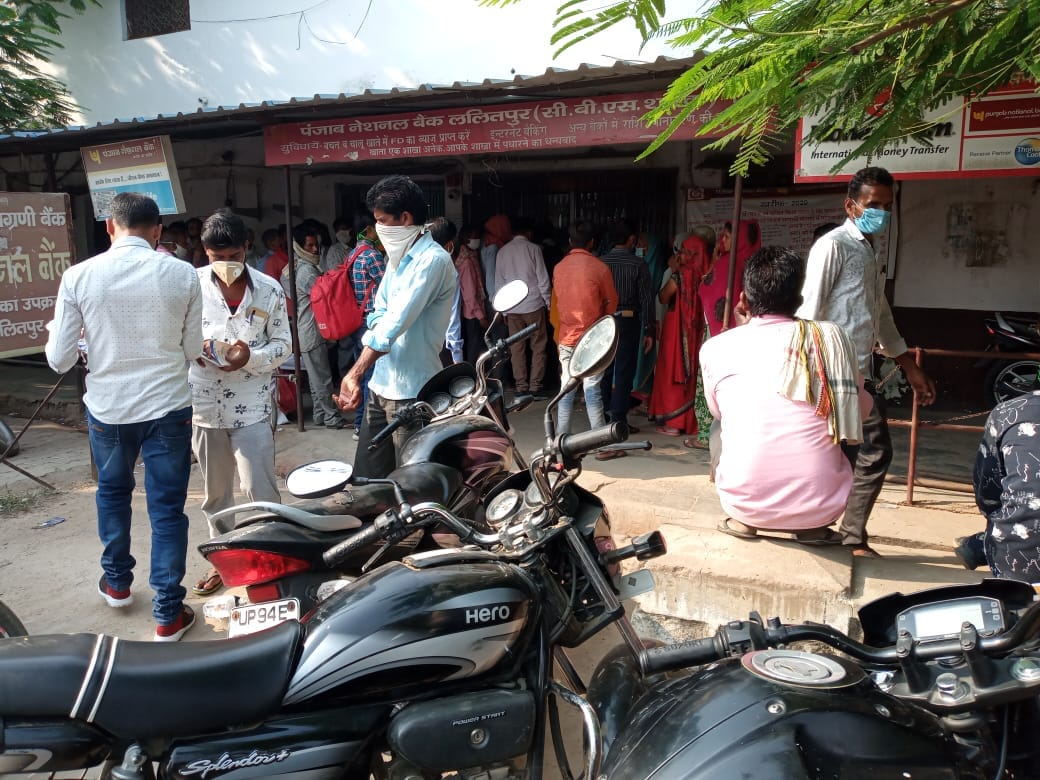 बैंक के बाहर सामाजिक दूरी का उल्लंघन करते लोग बैंक के बाहर सामाजिक दूरी का उल्लंघन करते लोग