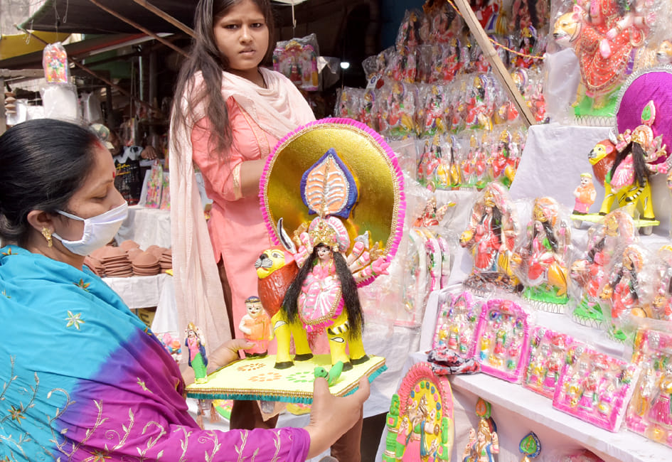नवाबगंज पर दुकान पर नवरात्रि के लिये सांझी खरीदती महिला