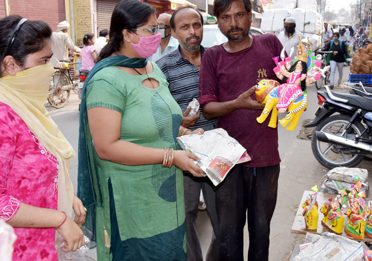 बेहट रोड़ स्थित दुकान पर नवरात्रि के लिये सांझी खरीदती महिलाएं