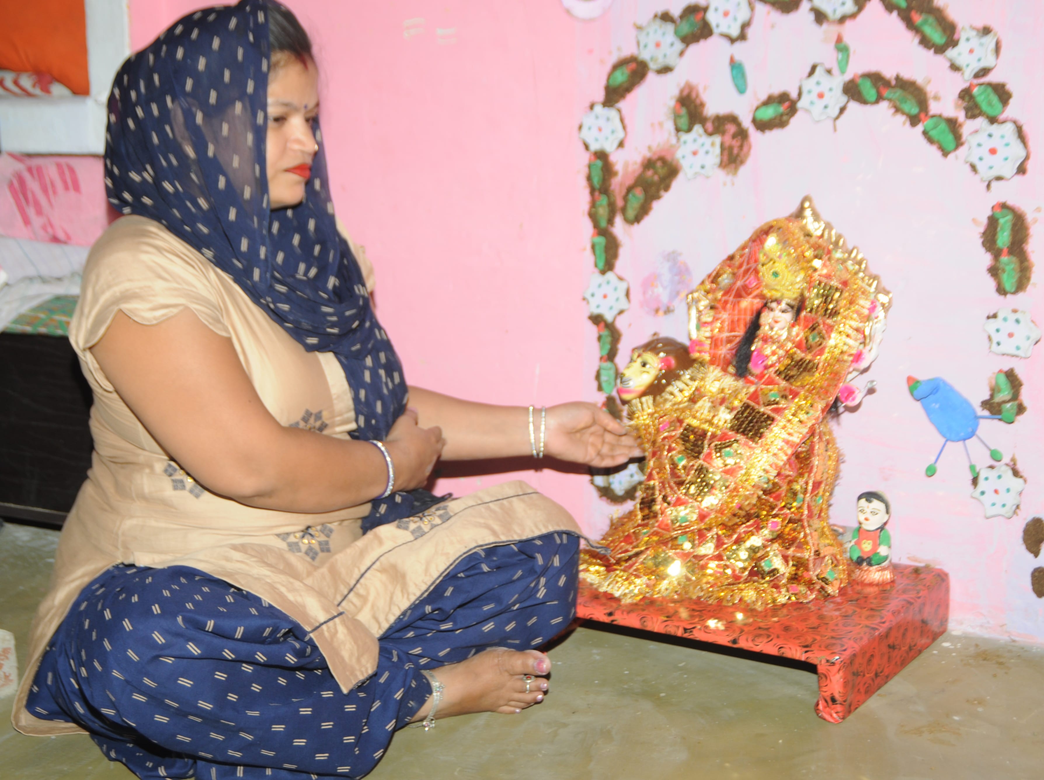 शामली घर में सांझी को सजाती महिला शामली घर में सांझी को सजाती महिला