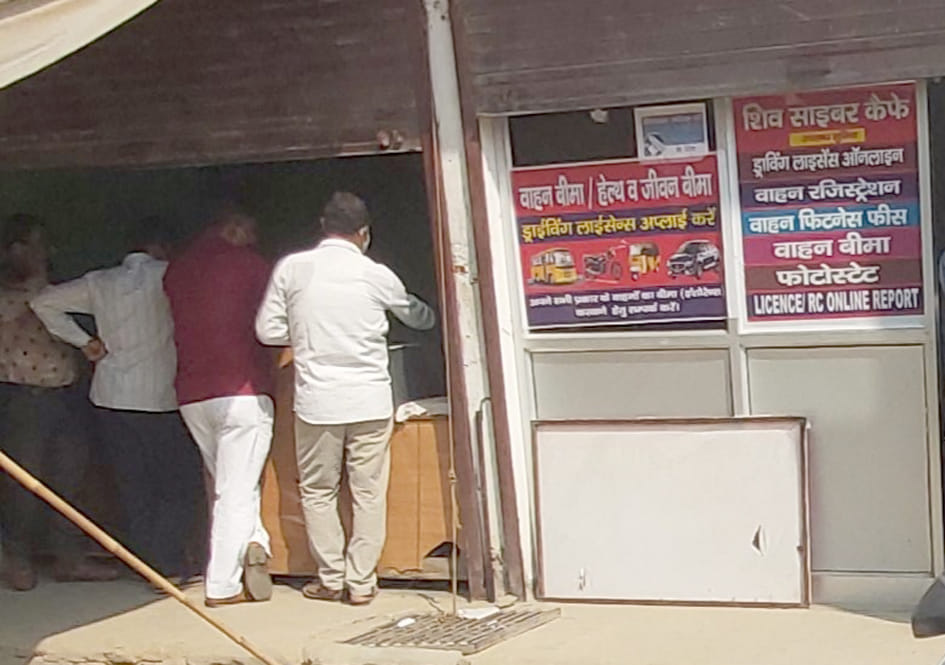 आरटीओ कार्यालय के बाहर एक काउंटर पर फिटनेस सर्टिफिकेट और बीमा के बारे में जानकारी लेते वाहन स्वा?