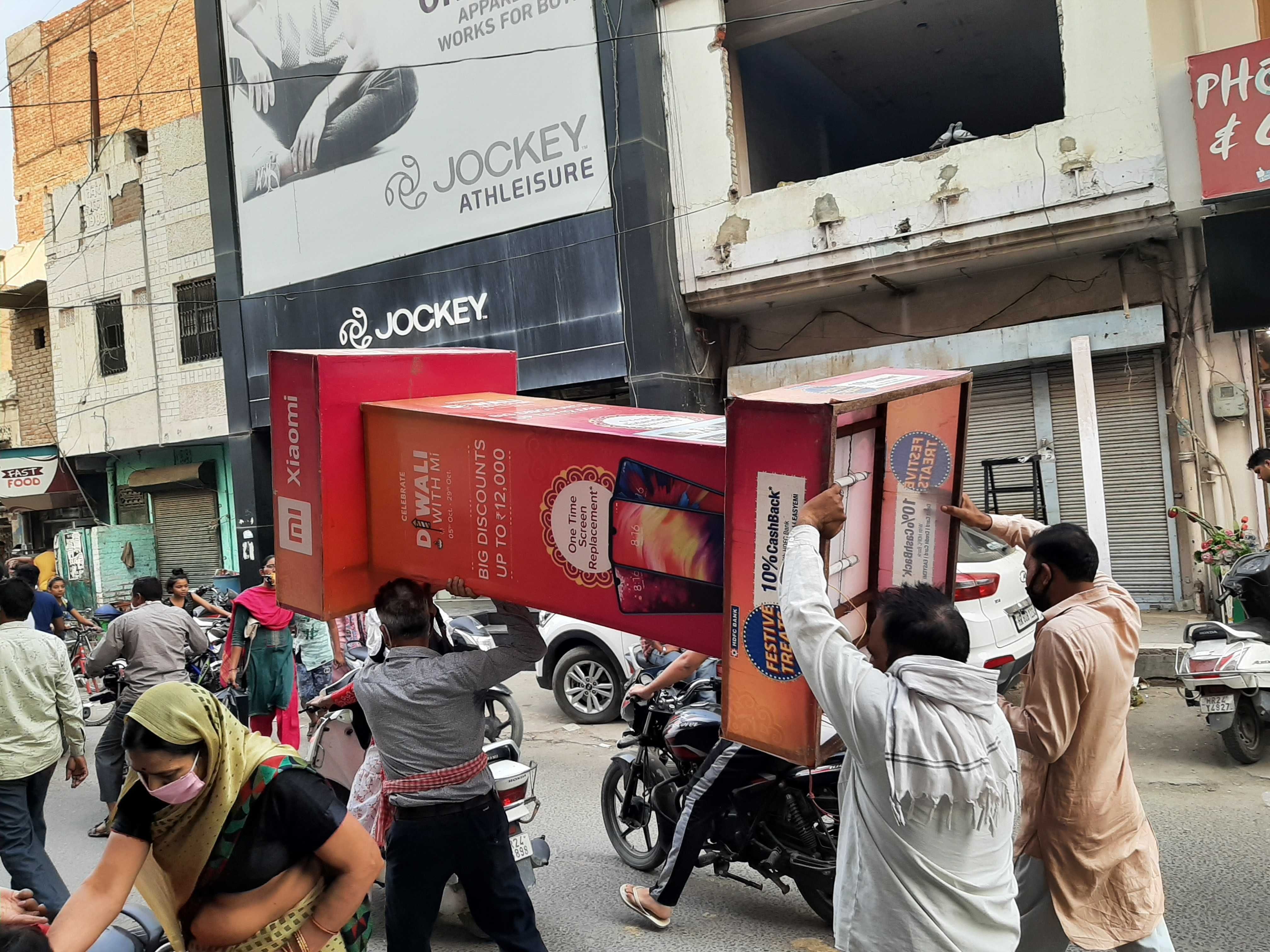 दुकान के आगे रखा बोर्ड लेकर जाते नप कर्मी। दुकान के आगे रखा बोर्ड लेकर जाते नप कर्मी।