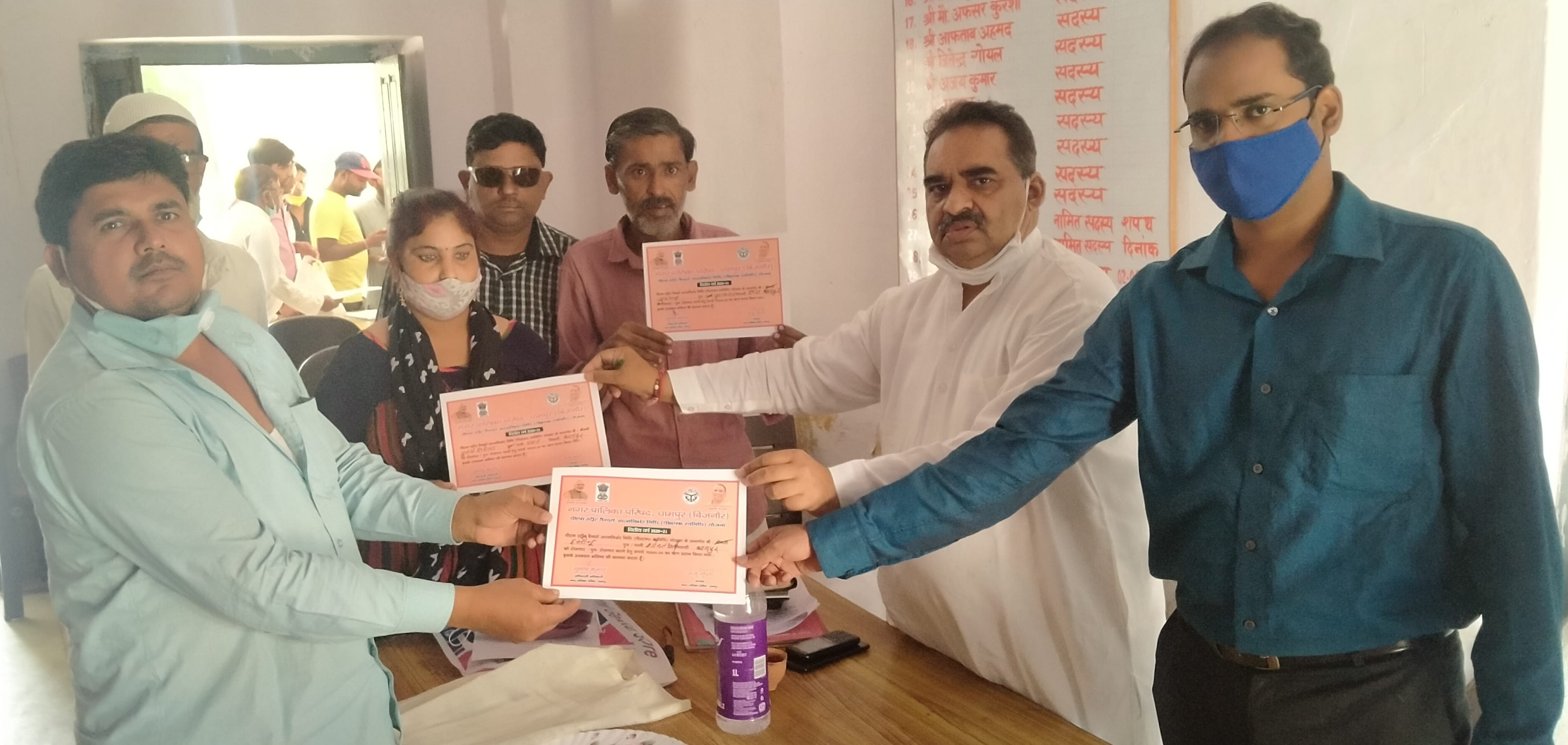 01ड्ड  धामपुर पालिका में रेड़ी चलाने वालो को लोन कार्डो को वितरण करते पालिकाध्यक्ष राजू गुप्ता।