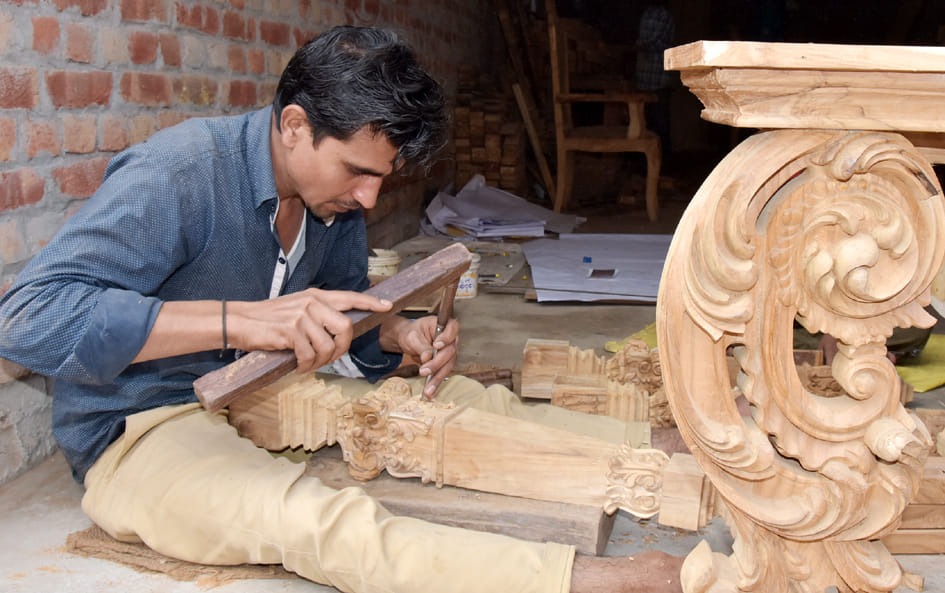 हयात कॉलोनी में लकड़ी पर नक्काशी करता कारीगर
