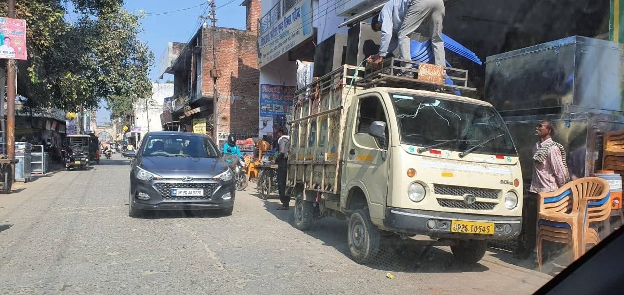 जाटों चौराहा के पास दुकानों के बाहर सामान लोड करती गाड़ी।