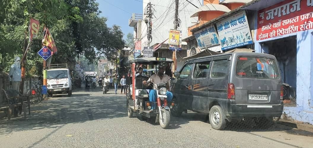 छतरी चौराहे से बाजार जाने वाली सड़क पर सड़क किनारे खड़े वाहन।