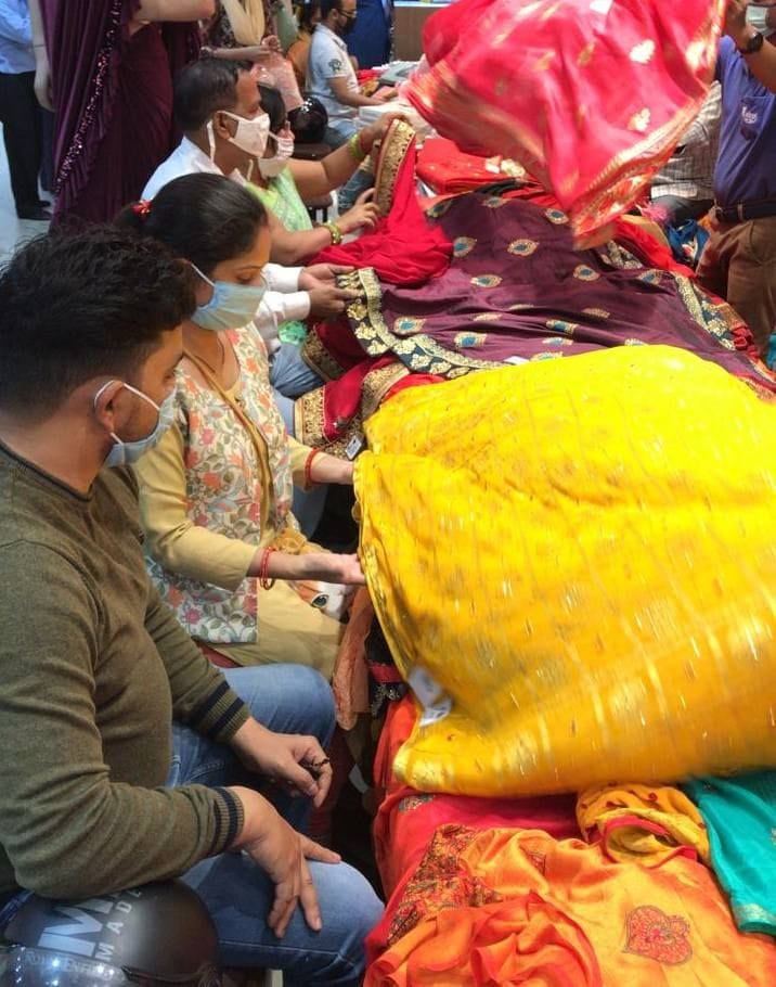 एक शोरुम पर साड़ी की खरीदारी करते ग्राहक।