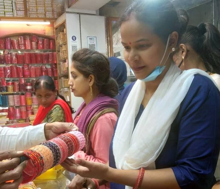 शहर में एक चूड़ी की दुकान पर चूड़ी को पसंद करती महिला शहर में एक चूड़ी की दुकान पर चूड़ी को पसंद करती महिला