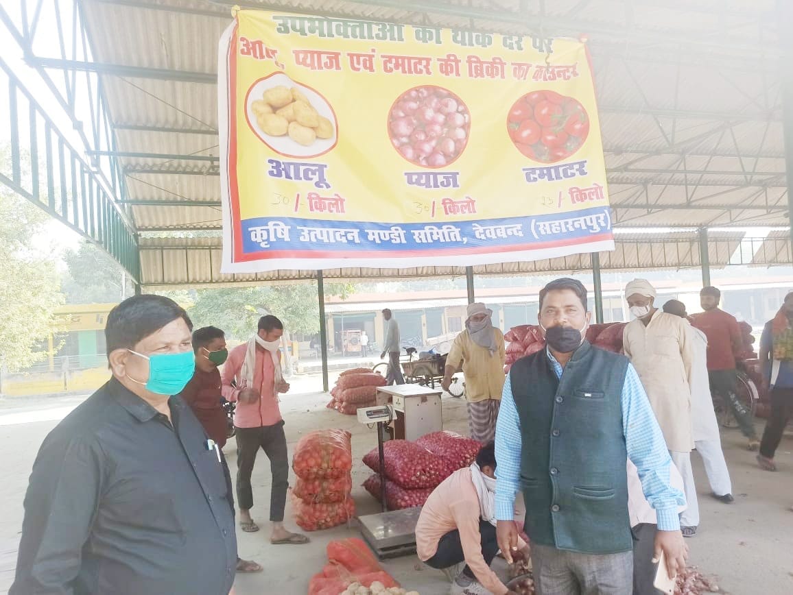 मंडी समिति में लगे स्टाल पर आलू प्याज समेत अन्य सब्जियों के भाव की समीक्षा करते अधिकारी