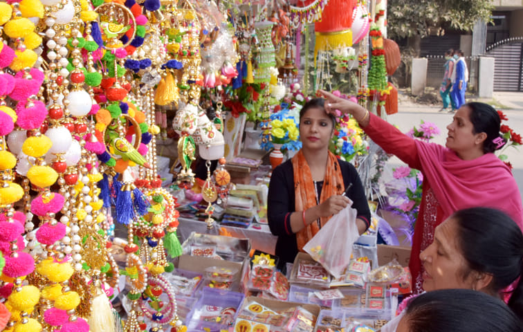 आवास विकास में दीपावली पर घर की सजावट के लिये समान खरीदती महिलाएं
