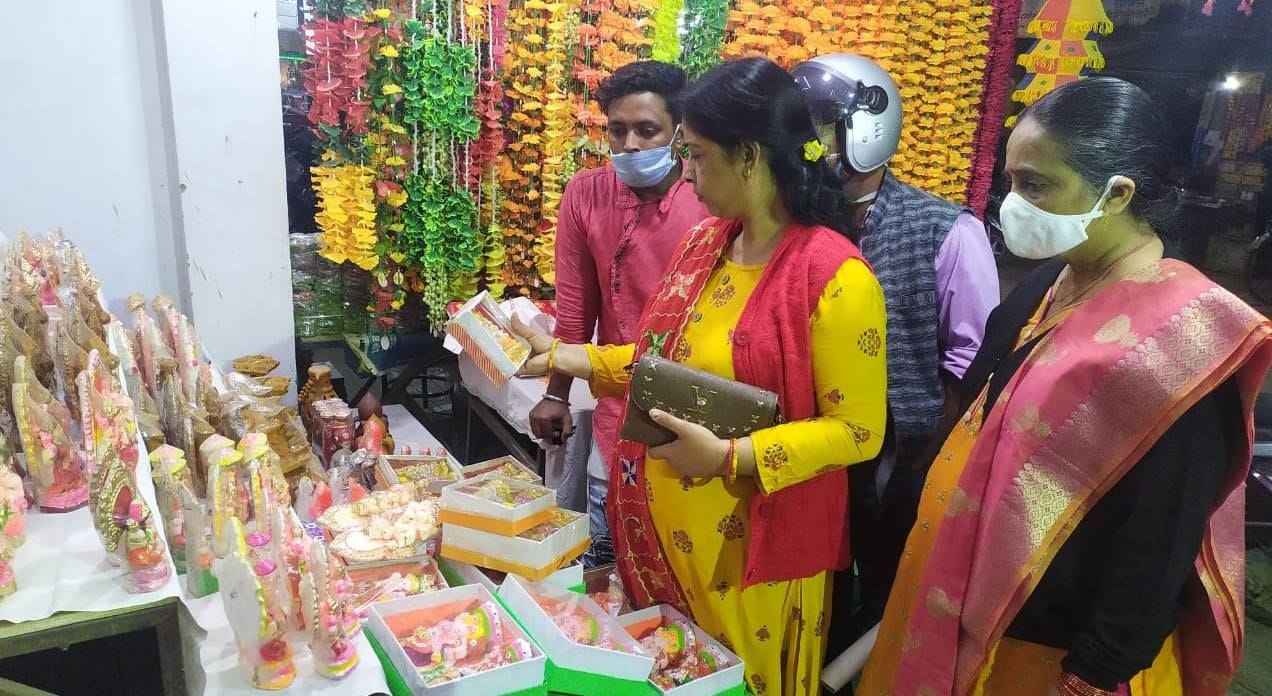 स्टेशन रोड पर एक दुकान पर मूर्ति की खरीदारी करती महिलाएं स्टेशन रोड पर एक दुकान पर मूर्ति की खरीदारी करती महिलाएं