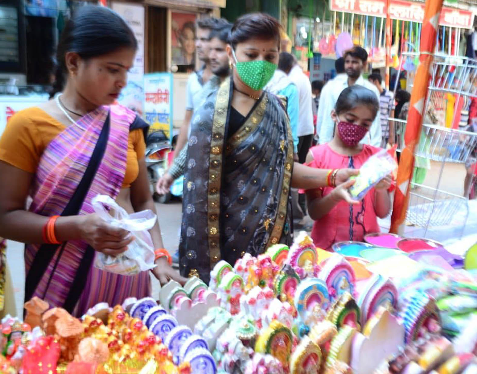 स्थानीय कुम्हारों द्वारा तैयार की गई लक्ष्मी-गणेश की प्रतिमाएं खरीदतीं महिलाएं। स्थानीय कुम्हारों द्वारा तैयार की गई लक्ष्मी-गणेश की प्रतिमाएं खरीदतीं महिलाएं।