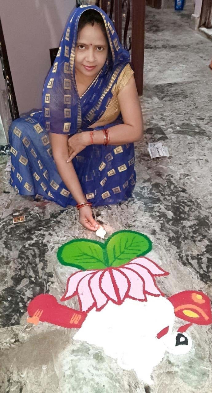 14एयूआरपी52- रंगोली बनाने के बाद दीप जलाती एक महिला 14एयूआरपी52- रंगोली बनाने के बाद दीप जलाती एक महिला