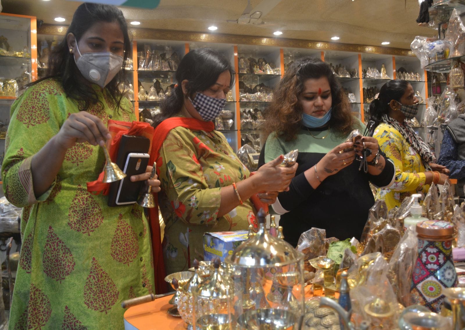 बर्तना बाजार में मूर्ति की खरीदारी करती महिलाएं। बर्तना बाजार में मूर्ति की खरीदारी करती महिलाएं।